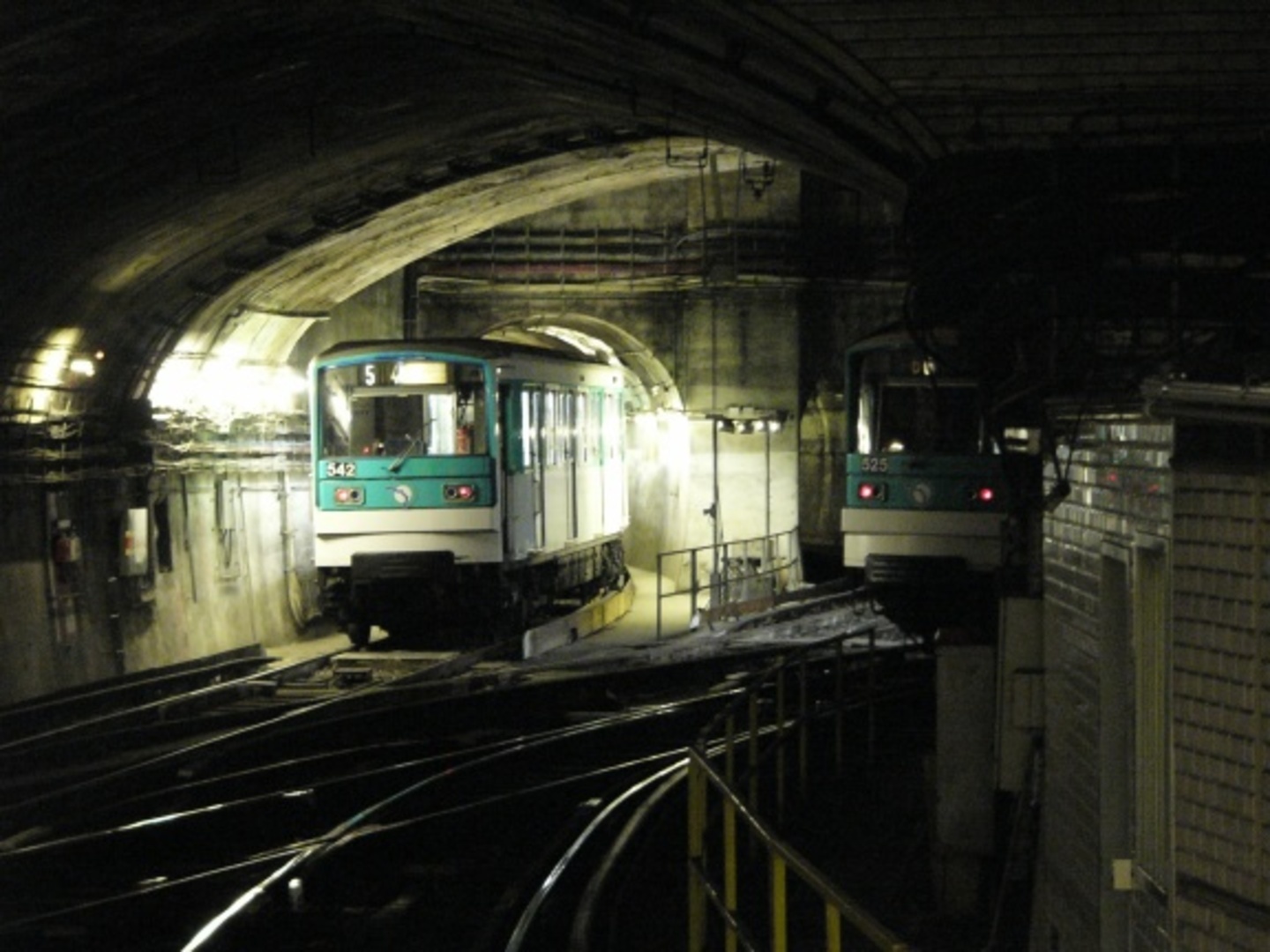 Paris Metro train emerging from tunnel at a historic station